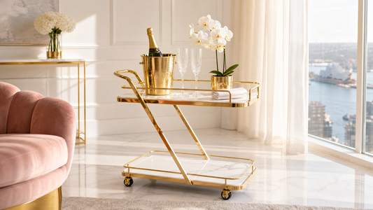 Marble bar cart Australia — gold Z-frame service cart with white marble-look shelves styled in a bright luxury Sydney apartment