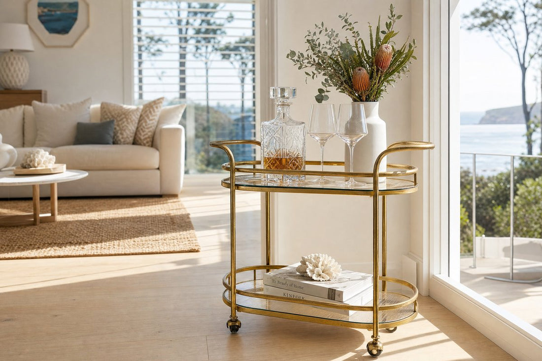 Drinks trolley Newcastle Australia — gold two-tier bar cart in a bright coastal Australian home with natural light, crystal decanter and native botanicals