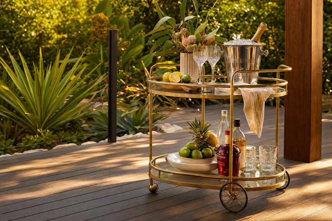 Outdoor bar cart Australia — gold oval bar cart styled on a timber alfresco deck with tropical greenery and champagne bucket