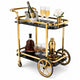 Le Versailles two-tier gold bar cart with black glass shelves styled with crystal decanters and glassware