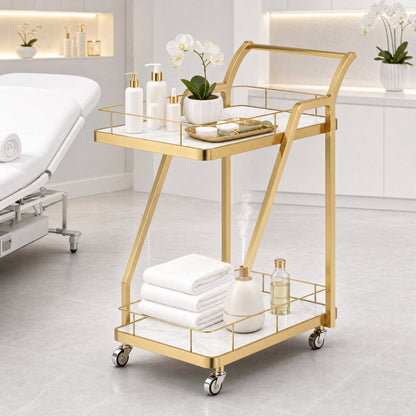 The Mosman Two-Tier Gold Marble-Look Service Cart featuring a striking Z-frame and white faux-marble shelves, styled with wine and glasses and day spas.