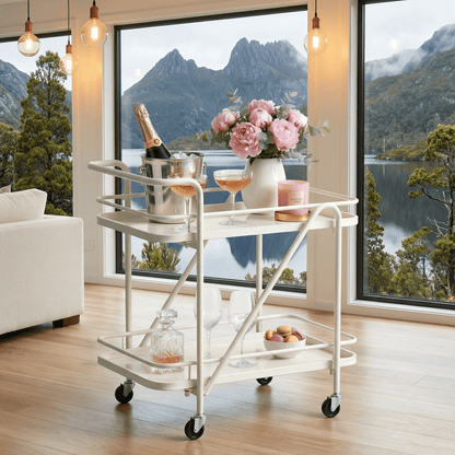 Close-up of The Brighton Two-Tier Metal Service Cart in black, styled with coastal deco accessories by Royal Bar Carts.