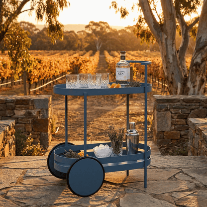The Kirra Nordic Oval Bar Cart in blue, styled with glassware and coastal decor by Royal Bar Carts