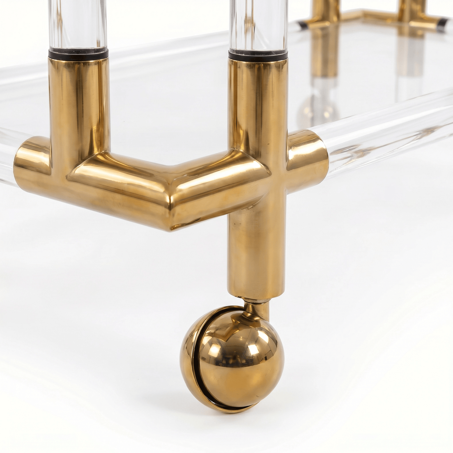 Close-up of The Lake Mackenzie two-tier acrylic gold bar cart showcasing sleek gold frame and clear acrylic shelves in modern setting