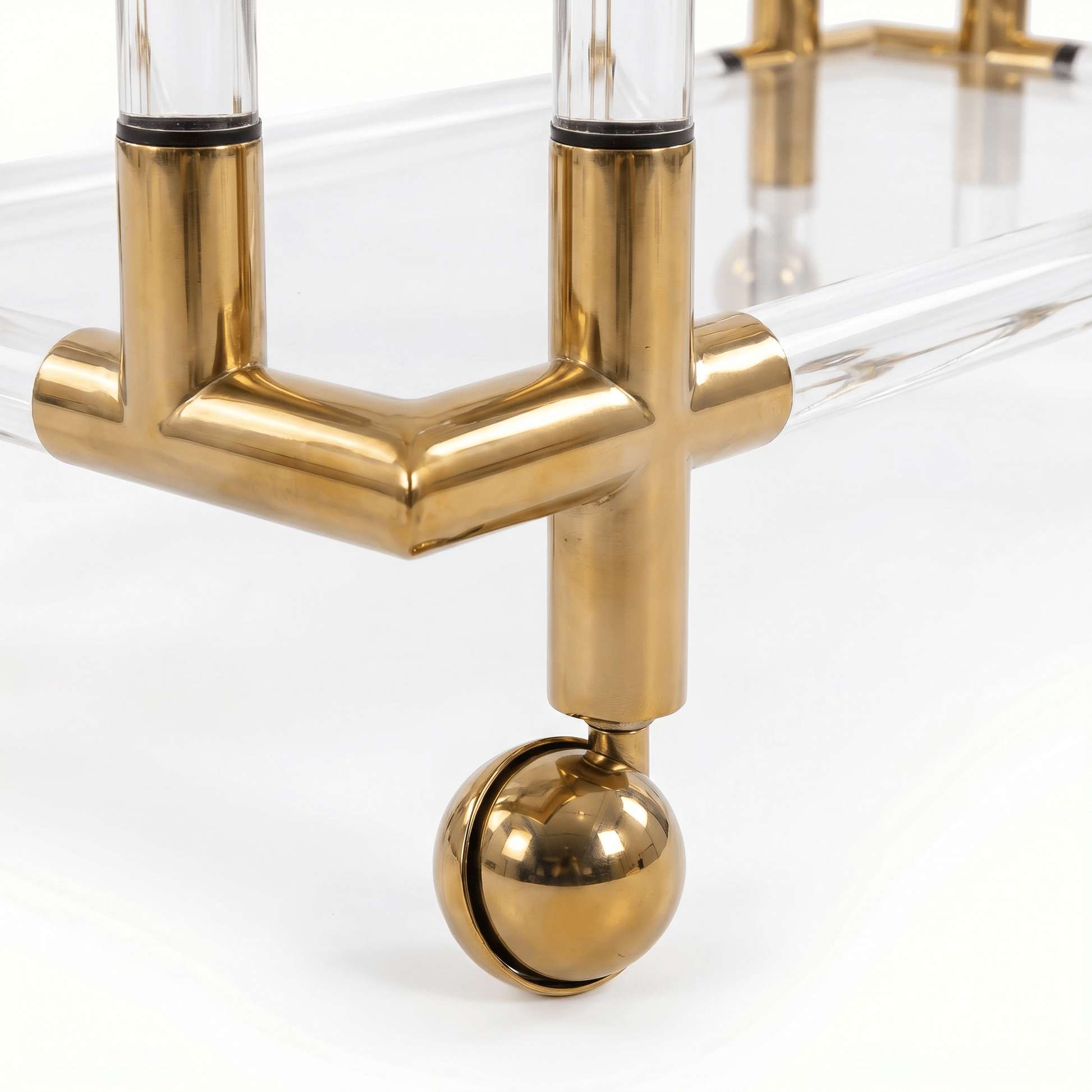 Close-up of The Lake Mackenzie two-tier acrylic gold bar cart showcasing sleek gold frame and clear acrylic shelves in modern setting