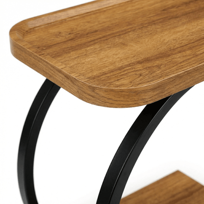 Close-up of Noosa Curved Metal Sofa Table in black with coastal deco accents, showcasing its sleek curved design and sturdy frame