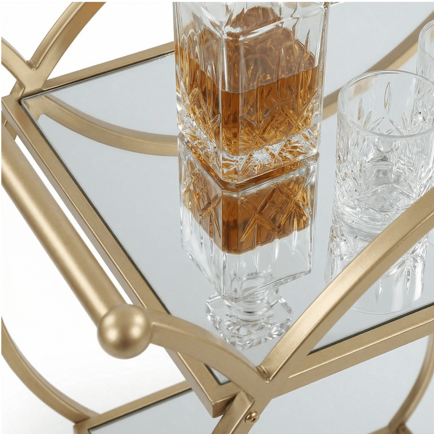 Close-up of The Orion Gold Circle Bar Cart’s elegant gold frame and glass shelves styled with cocktails and barware
