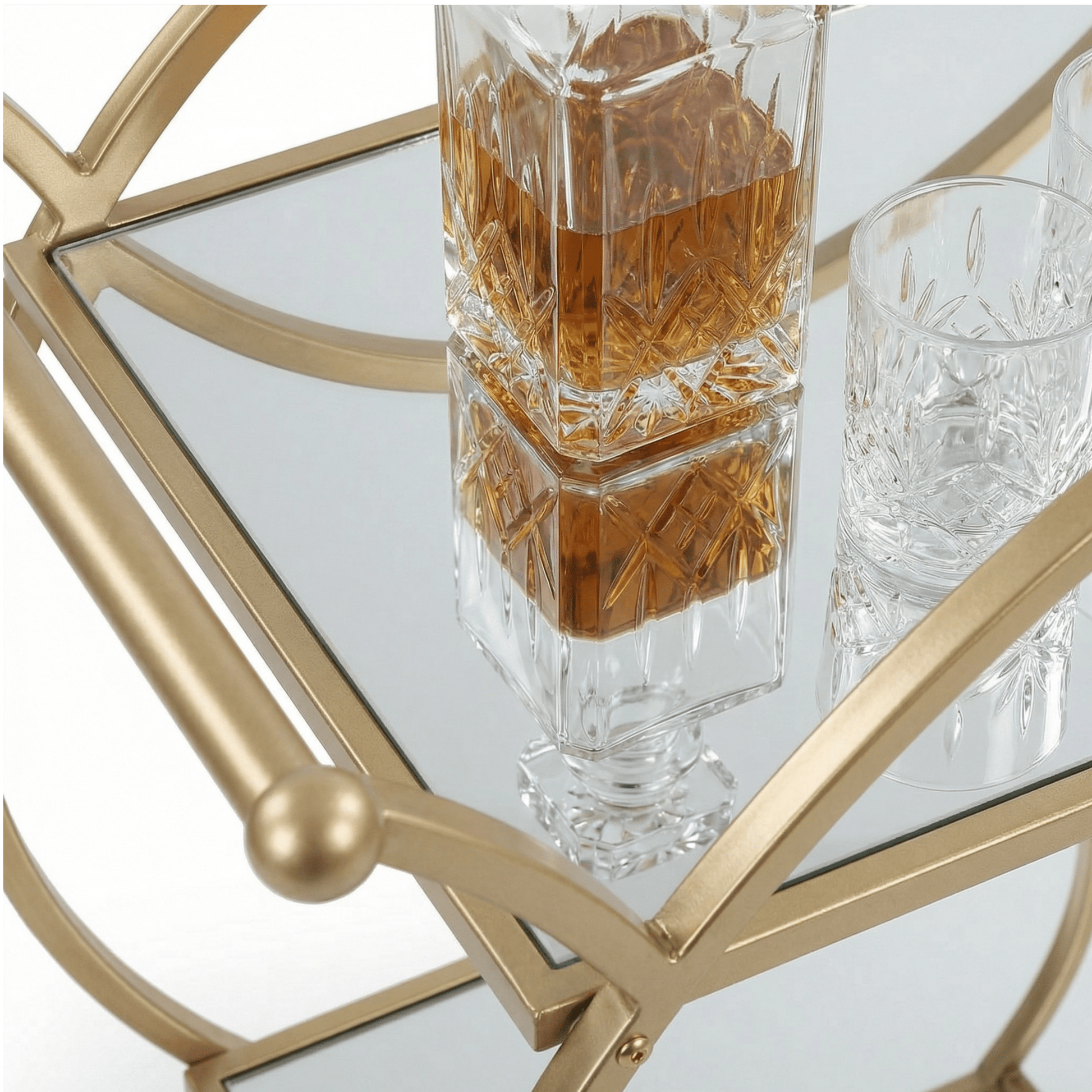 Close-up of The Orion Gold Circle Bar Cart’s elegant gold frame and glass shelves styled with cocktails and barware