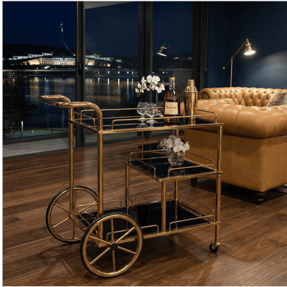 Close-up of Sovereign Bar Cart’s sleek black frame and glass shelves styled with contemporary deco accessories.