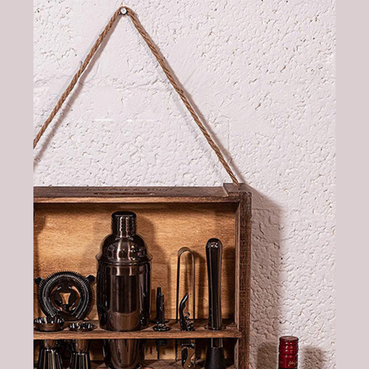 The Shaker — wall-mounted rack in dark timber, hung on a rope