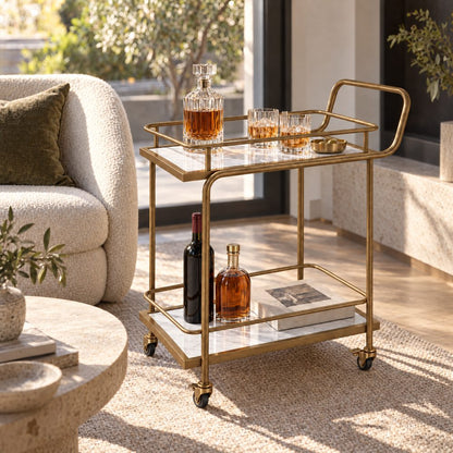 The Subiaco Nordic Service Trolley in Aged Brass with white marble-look shelves in a Melbourne living room, beside a bouclé sofa with the garden through the window