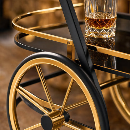 Close-up detail of The Waldorf Art Deco Beverage Cart's oversized gold spoke wheel and dark glass shelf